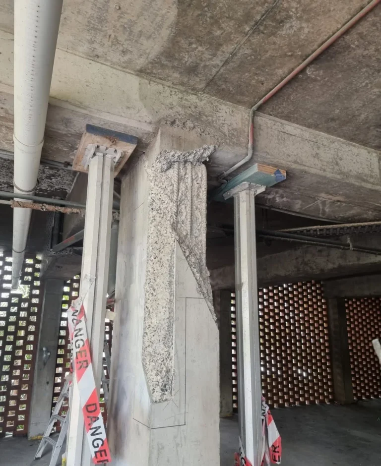 Temporary structural shoring supporting a concrete slab where the column interface has failed due to high local stresses and poor joint detailing in an industrial facility.